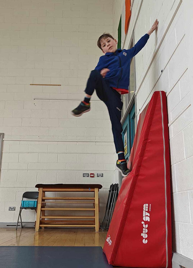 Boy jumping up onto wall