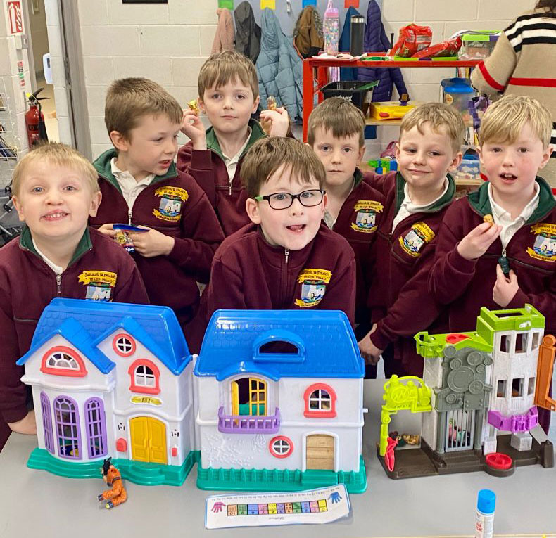 Children playing with a toy house at the Infant After School Club